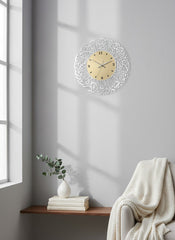 Decorative wall clock on a gray wall with a window and books in the background