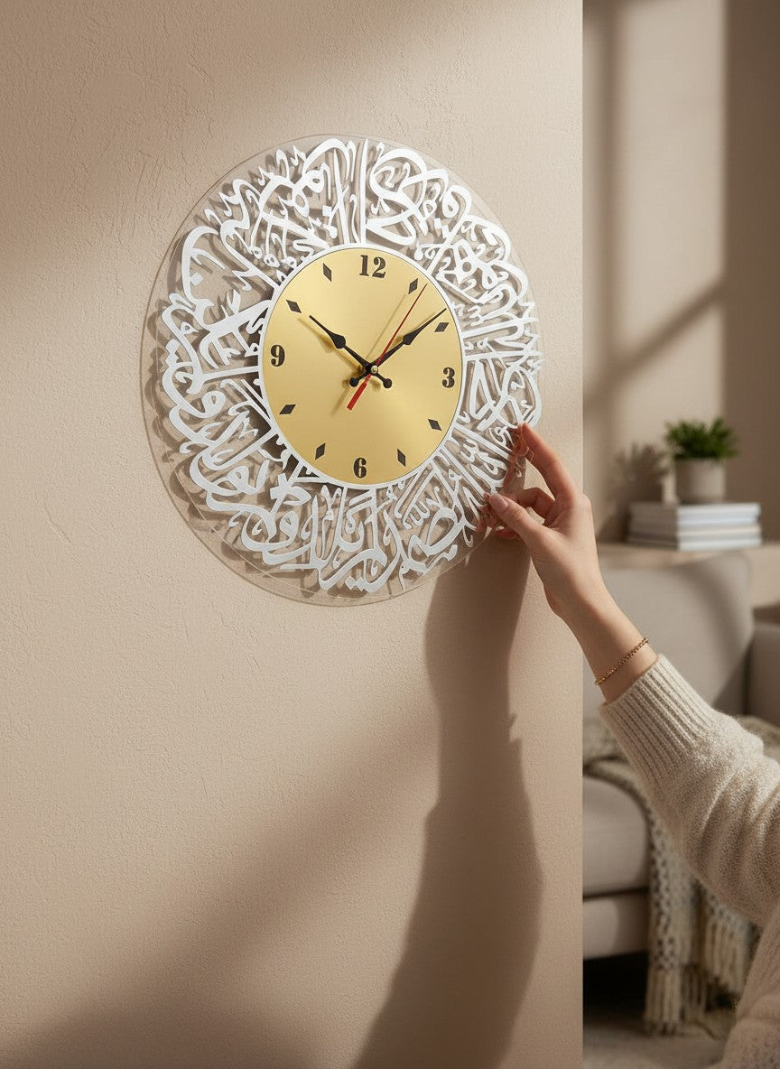 Decorative wall clock with intricate design being attached to a wall.