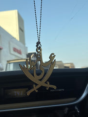 Decorative car hanging with Arabic text on a car dashboard